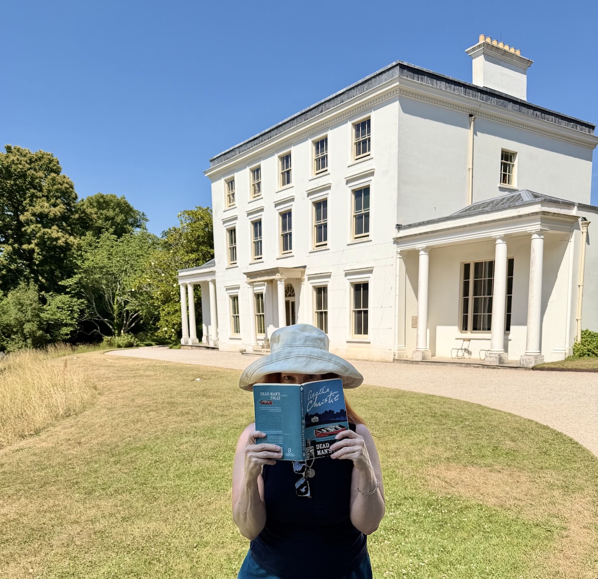 the author in a hat and holding a book in Front of Greenway, Devon, Uk.