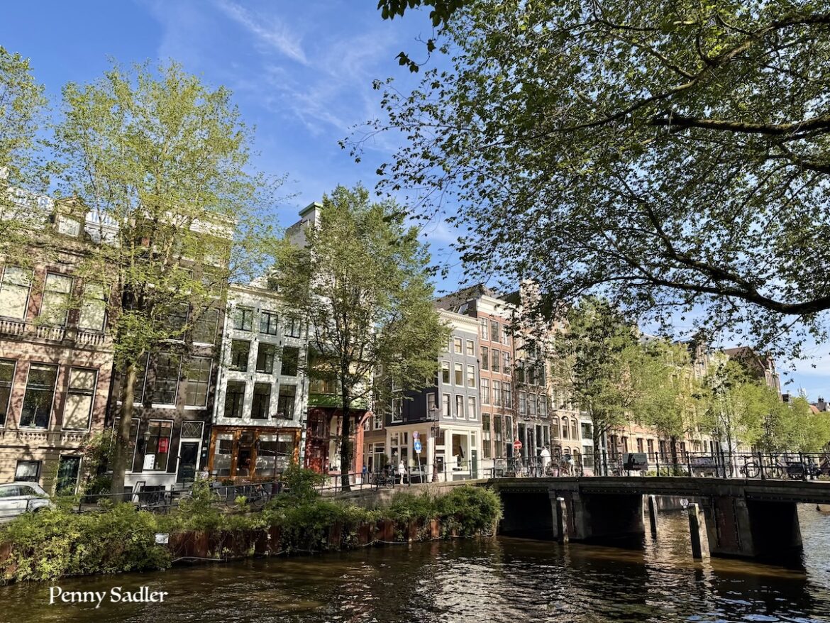 Historic Amsterdam canal houses and bridge on a sunny day, one day in Amsterdam