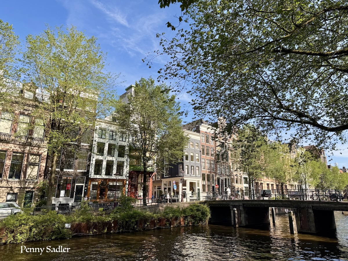 Historic Amsterdam canal houses and bridge on a sunny day, one day in Amsterdam
