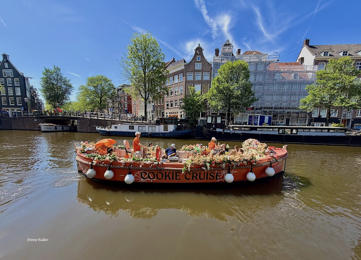 Tourist canal boat decorated with flowers on the Prinsengracht Canal