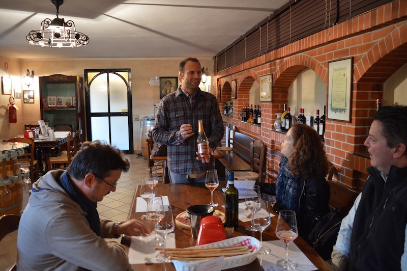 People gathered around a table tasting Barbaresco wine in the Francone tasting rooo, Neive.