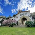 Santa Barbara County courthouse with pink flowers and palm trees on a clear blue day.