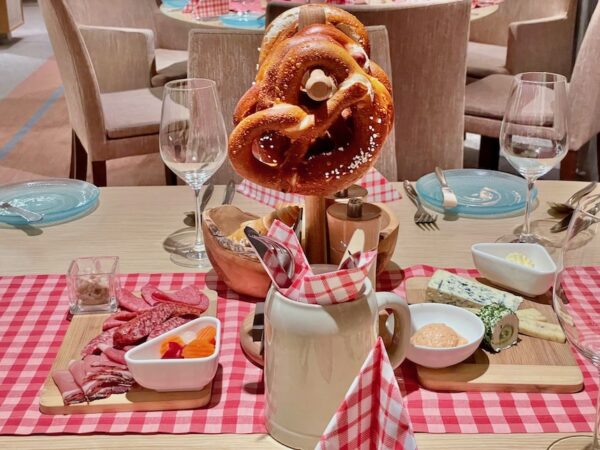 Pretzels, cheeses, and meat on a red and white table cloth on the Viking Viljahalm.