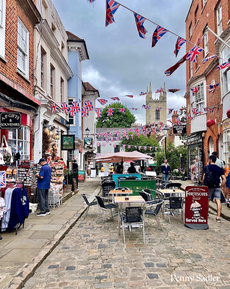 Colorful bunting decorating historic shops near The Royal Windsor Castle.